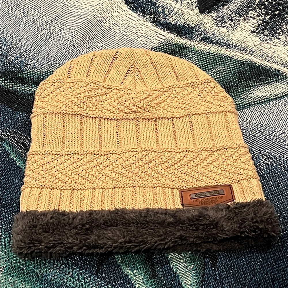 SONG TING" leather patch, is a unisex fleece-lined cable knit hat.